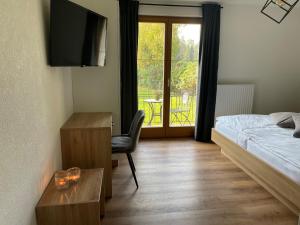 sypialnia z łóżkiem, biurkiem i telewizorem w obiekcie Seaways Apartments w mieście Schiefling am See