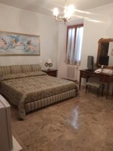 um quarto com uma cama, uma mesa e uma secretária em Antica casa di famiglia em Castiglione del Lago