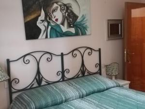 um quarto com uma cama com um quadro na parede em Antica casa di famiglia em Castiglione del Lago