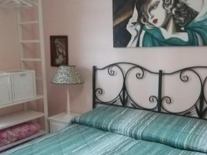 カスティリオーネ・デル・ラーゴにあるAntica casa di famigliaのベッドルーム1室(ベッド1台付)が備わります。壁には絵画が飾られています。