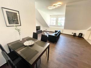 uma sala de estar com uma mesa de jantar e um sofá em Ferienwohnung Augenblick - Stylisches Apartment in der besten Altstadtlage von Erfurt em Erfurt