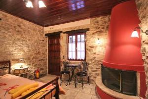 a bedroom with a fireplace and a bed and a table at Mountain Ηouse in Arcadia in Vytina
