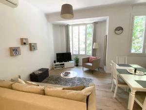 ein Wohnzimmer mit einem Sofa und einem Tisch in der Unterkunft Stylish two-bedroom apartment -StayInAntibes - 5 Soleau in Antibes