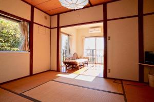 an empty living room with a couch and a window at Healing space tajima Shinmoe in Kirishima