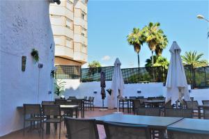 um restaurante com mesas e guarda-sóis brancos em Gran Hotel Toledo em Onda