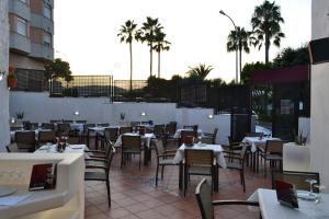um restaurante com mesas e cadeiras e palmeiras em Gran Hotel Toledo em Onda