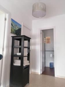 Habitación con estantería negra y toallas plegadas en Unifamiliar adosada con 3 dormitorios y 110m2, en Ronda