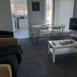 een woonkamer met een bank en een tafel en stoelen bij South Shield's Hidden Gem Amethyst 3 Bedroom House Sleeps 6 Guests in South Shields