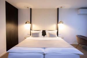 a bedroom with a large white bed with two pillows at House Klasika in Bled