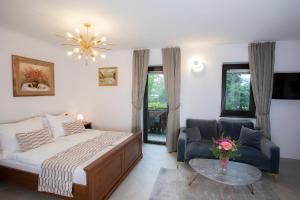 a bedroom with a bed and a chair and a table at House Klasika - Adults Only in Bled +88 photos