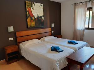 two beds in a bedroom with blue towels on them at Villa Coral in Corralejo +21 photos