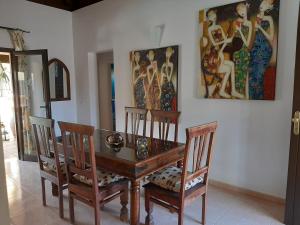 a dining room with a wooden table and two chairs at Villa Coral in Corralejo