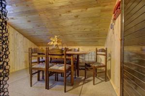 a dining room with a wooden table and chairs at Planinska kuća Kamin in Jahorina +11 photos
