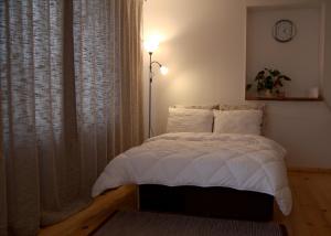 a bedroom with a bed and a window with a clock at Emilie's Apartments in Liepāja
