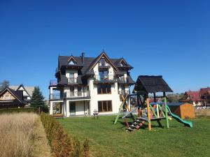 a large house with a playground in front of it at Tatry Panorama in Zakopane