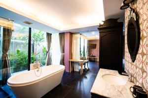 a bathroom with a large tub and a sink at See Sea Villa Phuket SHA in Patong Beach