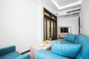 Sala de estar con 2 sofás azules y TV en Noor Land Hotel en Bagdad