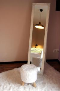 a mirror with a stool in front of a bedroom at FeWo-Silberborn in Holzminden