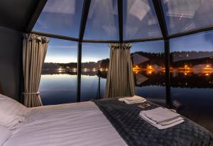 1 dormitorio con 1 cama frente a una ventana grande en Lake Igloo Ukkohalla en Hyrynsalmi