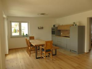 Ferienwohnung an der Ach في Oberhausen: مطبخ وغرفة طعام مع طاولة وكراسي