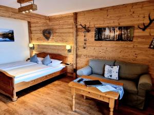 a bedroom with a bed and a couch and a table at Seehotel Hartung & Ferienappartements in Füssen
