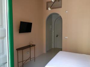 a bedroom with a bed and a tv on a wall at Luciani 33 luxury rooms in Salerno