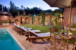 a patio with lounge chairs and a swimming pool at Posada Borravino in Chacras de Coria