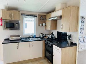 a small kitchen with a stove and a microwave at Bude holiday home in Bude