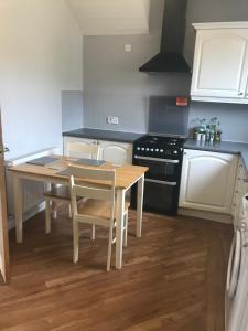 a kitchen with a table and chairs and a stove at The Avenue in Eyemouth