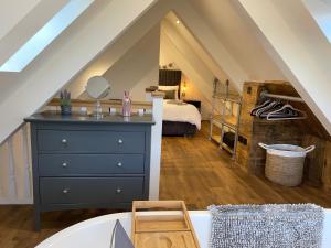 a attic bedroom with a blue dresser and a bed at Beechwood Nook- Crown Lodges in Crawshaw Booth