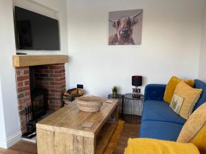 a living room with a blue couch and a table at Beechwood Nook- Crown Lodges in Crawshaw Booth