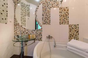 bagno con vasca e specchio di Cozy Apartment in Most City Center a Dnipro