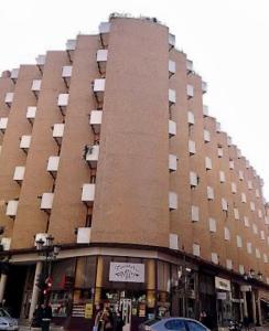 un gran edificio de ladrillo con un cartel delante en El Loft de Andy, en Oviedo