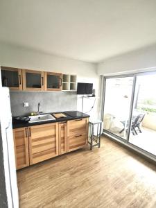 a kitchen with a sink and a large window at Appartement Vue Mer 208 in Canet-en-Roussillon