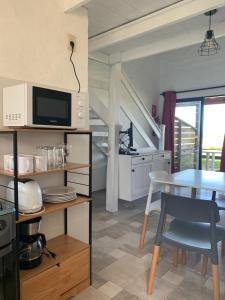 a kitchen and dining room with a table and a microwave at Sabai Casas de Playa in La Paloma