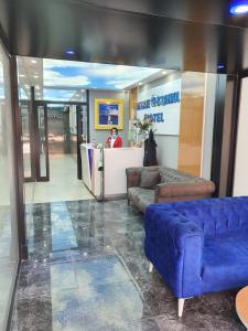 a lobby with a blue couch in front of a counter at SKYBLUE İSTANBUL HOTEL in Istanbul