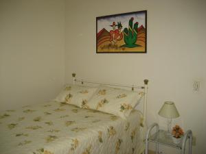 a bedroom with a bed and a picture on the wall at Hospedagem UniCanto in Campinas