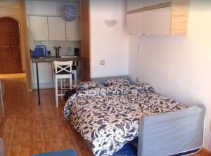 een kleine slaapkamer met een bed en een keuken bij STUDIO TAGORO in Costa Del Silencio