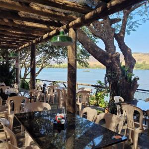 un restaurant avec vue sur l'eau dans l'établissement Pousada e Restaurante do Porto, à São João Batista do Glória