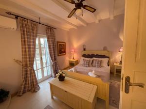 una camera da letto con un letto e un ventilatore a soffitto di Kalafatis Private Villa Mykonos a Kalafatis Altre 13 foto
