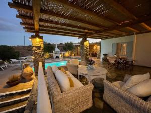 patio z krzesłami i stołem oraz basenem w obiekcie Kalafatis Private Villa Mykonos w mieście Kalafati