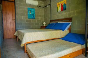 a bedroom with two beds with blue pillows at Casa do Pescador Camburi in Camburi +49 photos