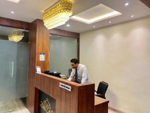 un homme est assis à la réception dans l'établissement Hotel Vrindavan Palace, à Indore