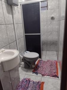 uma casa de banho com um WC, um chuveiro e um tapete. em Casa de Campo - Cambará do Sul em Cambará