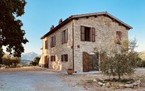 an old stone house with a door on a street at Casale Rancaglia in Gubbio