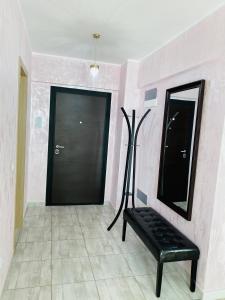 um quarto com um banco preto e um espelho em Dina Lux Iasi Apartment em Iaşi