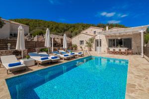 a swimming pool with chairs and a villa at Villa Daniela in Koríthion