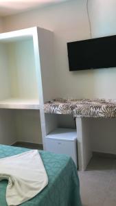 Cette chambre comprend un lit et un bureau. dans l'établissement Pousada Verde Suites, à Porto de Galinhas