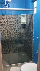une salle de bain avec une douche en verre et des toilettes dans l'établissement Pousada Verde Suites, à Porto de Galinhas