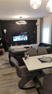 ein Wohnzimmer mit Sofas und einem TV an der Wand in der Unterkunft Seaview Apartment Moritz in Senj